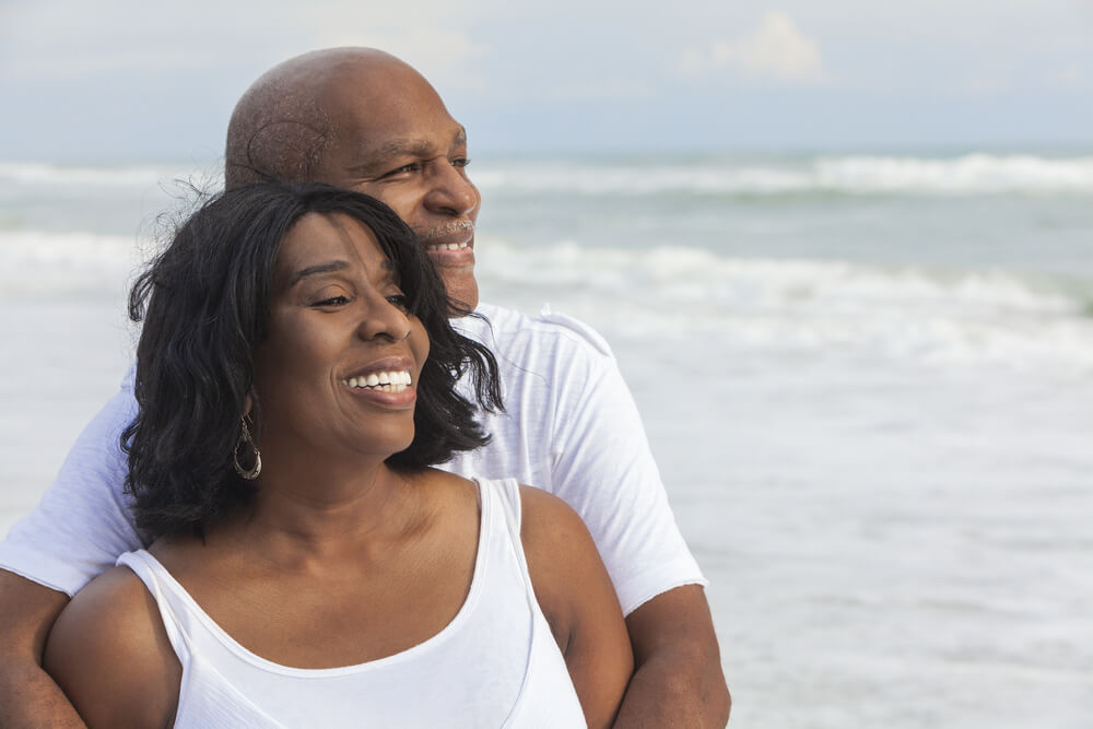 mature couple wearing white on the beach